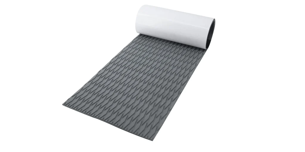 a roll of gray, textured material. The surface features a diamond - like pattern, which is designed to provide anti - slip properties. It has a white backing, suggesting it might be adhesive or for easy identification. This type of material is commonly used for applications such as flooring underlay, tool grip enhancement, or to add friction in areas where slipping is a concern. The roll is partially unrolled, allowing a clear view of both the textured surface and the smooth white backing.