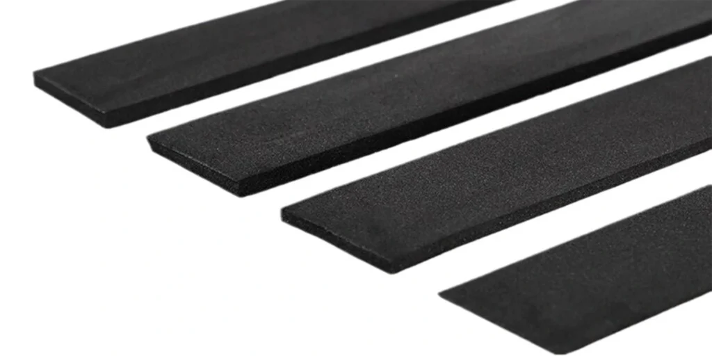 four black rubber strips of different lengths and widths, placed in a row on a white background. The texture of the strips appears to be smooth with no visible patterns or markings.