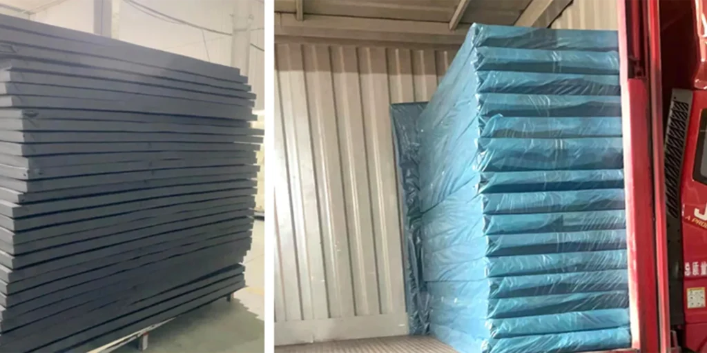 two stacks of rectangular objects, possibly panels or boards. On the left side, there is a stack of dark-colored items that appear to be made of some kind of solid material, perhaps metal or plastic. They are neatly arranged in rows and columns.On the right side, we see another stack of similar-looking items but wrapped in blue protective film. These also seem to be organized systematically with each layer separated by cardboard or other material for protection during transport or storage. The setting appears to be an industrial environment, likely a warehouse or manufacturing facility where such materials are stored before use or distribution.