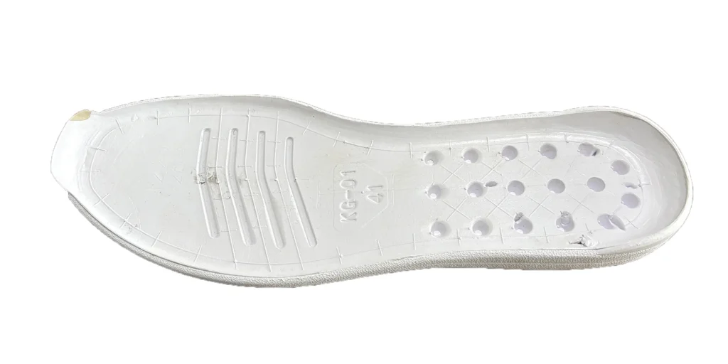 a white shoe sole has a textured surface with several holes and grooves, which may contribute to breathability and flexibility. There are also engraved markings on the sole, such as "XG - 01" and the size "41", indicating specific product details. The sole appears to be made of a lightweight material, suitable for use in footwear to provide comfort.