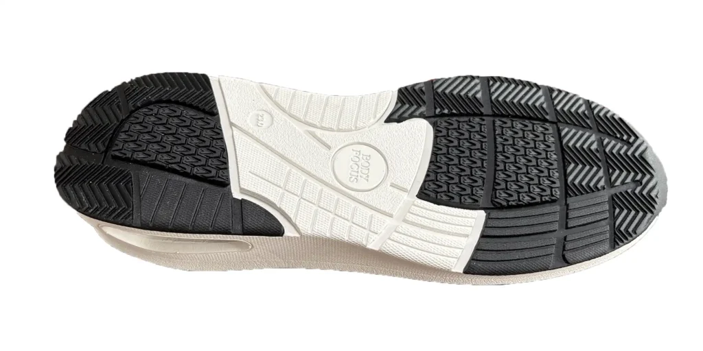 the bottom part of a shoe sole. It features a combination of black and white textured patterns, which are likely designed to enhance traction. In the center, there is a circular logo that reads "BODY FOCUS". The sole appears to be made from durable materials, suitable for providing stability and grip during various activities.