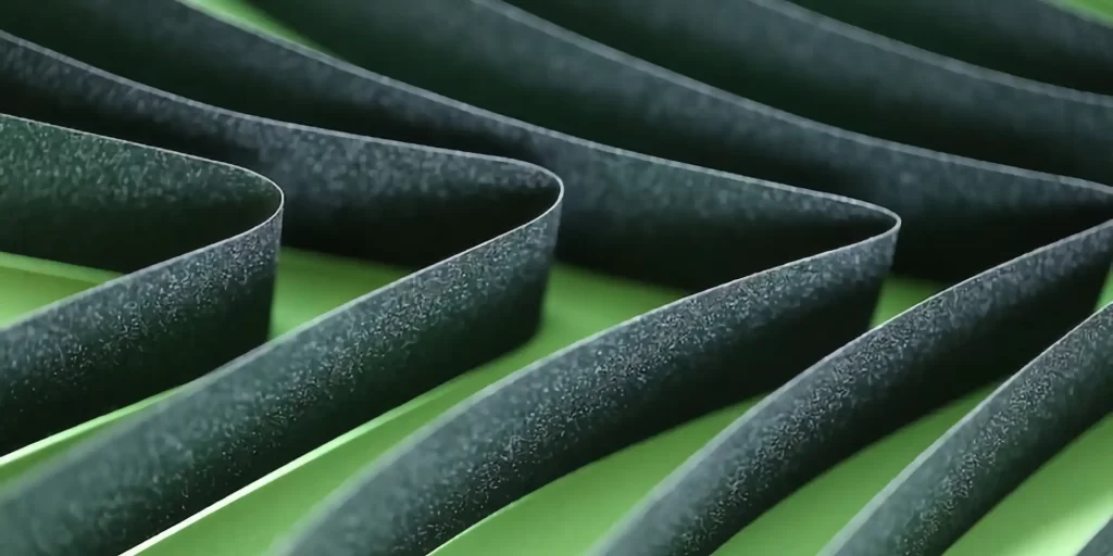 The image shows a wavy metal bar in black and green colors. These metal bars present a unique aesthetic because their shape and color contrast with the other elements in the background. This contrast makes the image stand out and emphasizes the unique look of the metal bars.