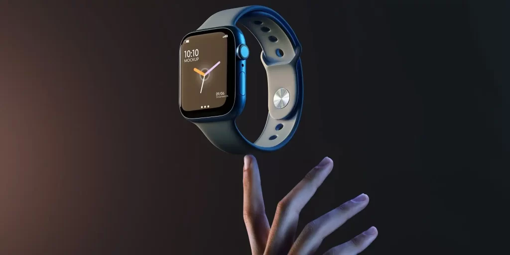 The hand of a man in a dark gray shirt holds an Apple watch palm upwards, the watch is shown hovering. The watch band is blue and the dial is black.