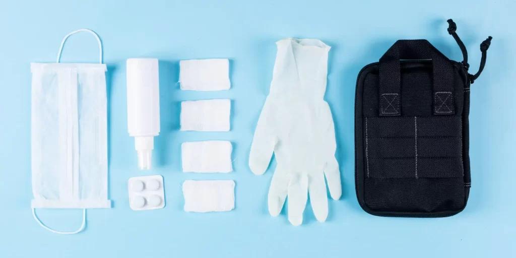 a flat lay of various medical or health safety items. It includes a face mask, possibly indicating the precautions taken during health-related situations like pandemics. There's a bottle that could be hand sanitizer, which is used for disinfecting to prevent the spread of germs. Gauze pads are commonly used for wound care, to clean or cover minor cuts or burns. The gloves are likely made of latex or nitrile, which are used for hygiene and protection during medical procedures or examinations. The black case on the right might be a carrying case, which could be used to store and transport these items conveniently. The reference to EVA foam in the file name suggests that this type of foam might be used within the carrying case due to its protective qualities. EVA (ethylene-vinyl acetate) is durable, resilient, and often used in packaging for its cushioning properties, making it ideal for protecting medical equipment and supplies.