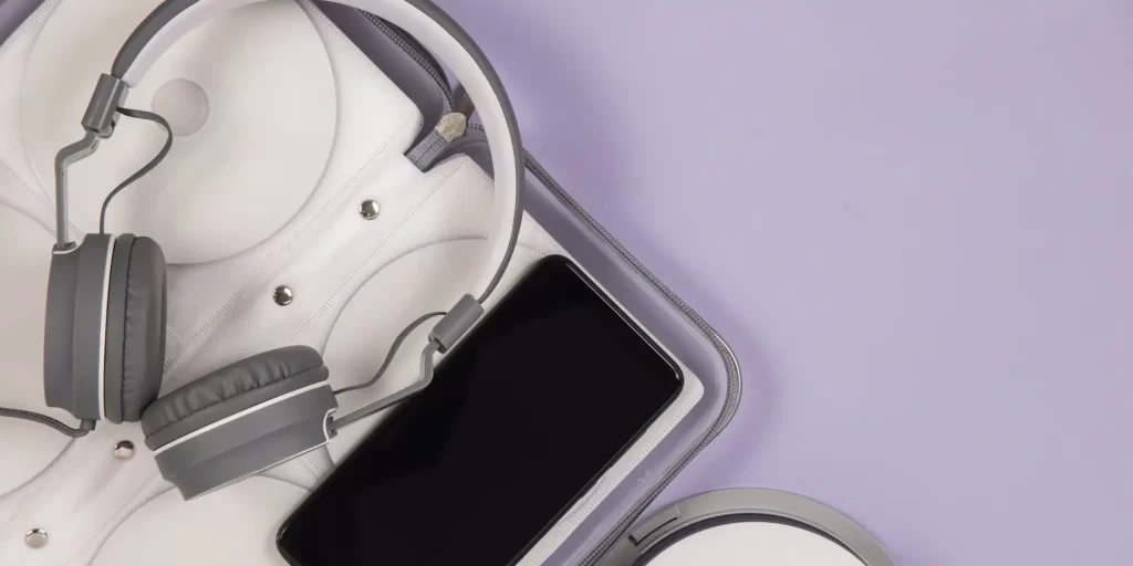 The headphones and cell phone lie quietly in the white box, seemingly waiting for their owners. The headphones have earmuffs on their ears and seem to be listening to music or stories; while the screen of the cell phone displays information, games or other entertainment. The scene is full of poetry, as if a mysterious world is waiting for its arrival.