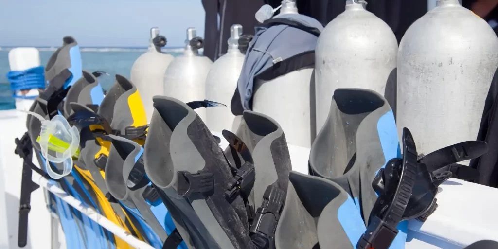 a selection of scuba diving gear, including several pairs of flippers and oxygen tanks, likely on a boat or near a diving site. The equipment is geared up for use, suggesting that divers might be nearby or in the water. EVA foam as an optimal solution for protective packaging in maritime equipment. EVA foam is a material known for its buoyant, waterproof, and durable properties, making it suitable for use in various water-related applications. In the context of diving equipment, EVA foam might be used in the manufacturing of flippers for comfort and fit, in the padding of oxygen tanks to prevent damage during transportation, or in the construction of buoyancy control devices.