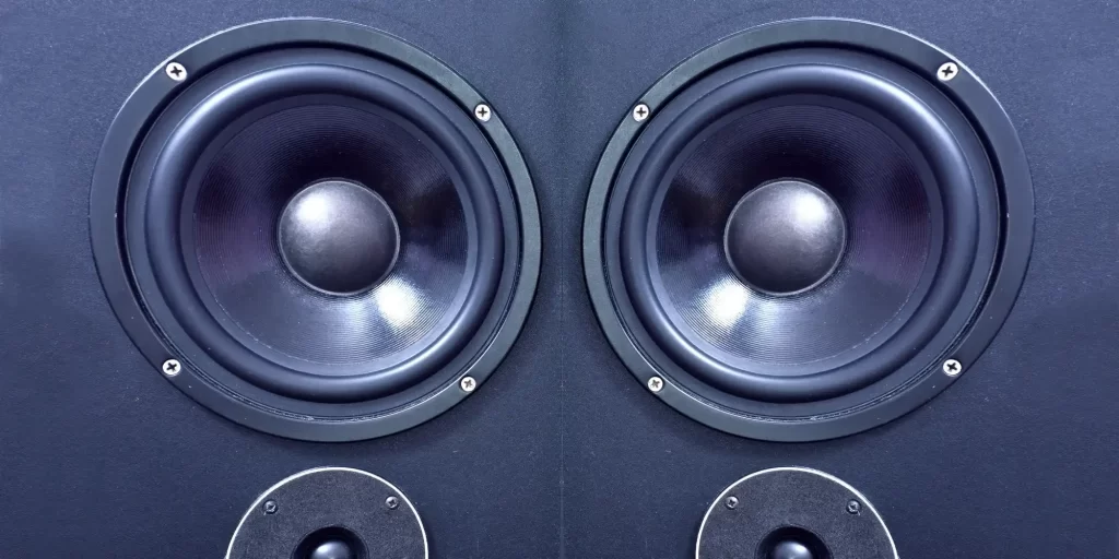 Two speakers, a black subwoofer and another white tweeter. They stood silently on the black background, as if frozen in time. The black subwoofer's low-frequency sound is calm and powerful, while the white tweeter is high and bright. The two intertwine together to show the charm and beauty of music. In the dark corners, these two huge sound systems seem to be forgotten, but their presence is so clear and distinct. Their voices seem to awaken the sleeping souls and bring infinite energy to the world.