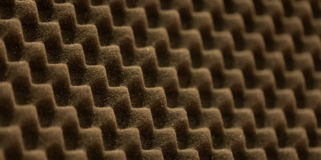 The picture shows a brownish-like sound deadening foam with a rough surface and many small holes.