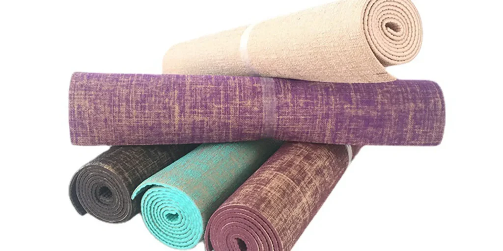 five different colors of yoga mats stacked together. From the bottom up, they are black, cyan, brown, purple and khaki. Each yoga mat is rolled up and bound with a transparent band. They look very soft and comfortable. These yoga mats can be used for various exercises such as yoga, pilates, meditation, etc., to provide better cushioning and comfort during exercise. At the same time, these yoga mats are also very convenient for carrying, because they can be easily folded and stored in a bag or drawer.