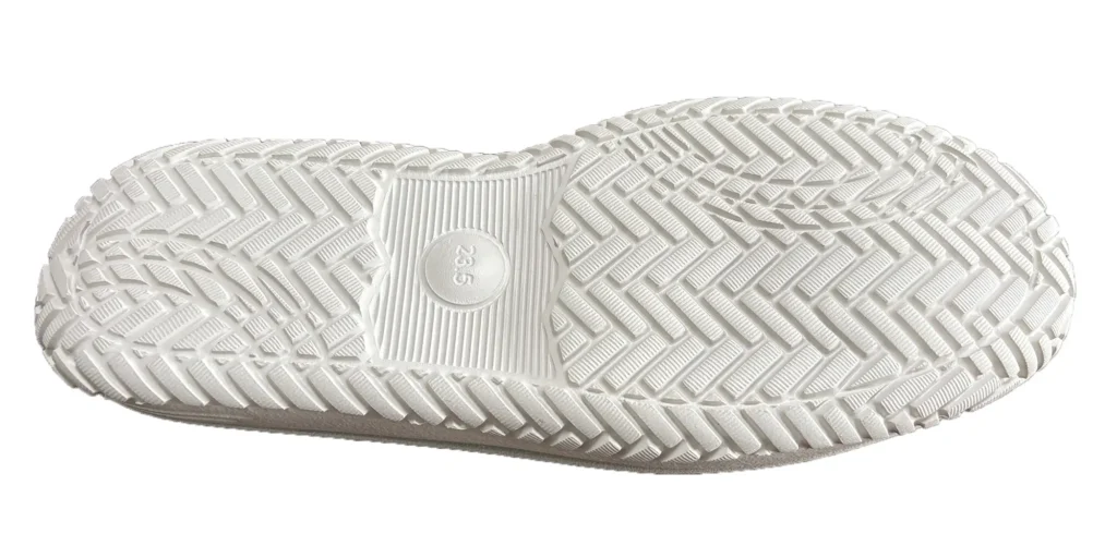a sole is white and has an elaborate textured pattern, which likely serves to enhance traction. In the center, there is a circular marking that reads "23.5", indicating the size of the shoe. The overall design suggests it is intended for functional use, providing grip and stability.