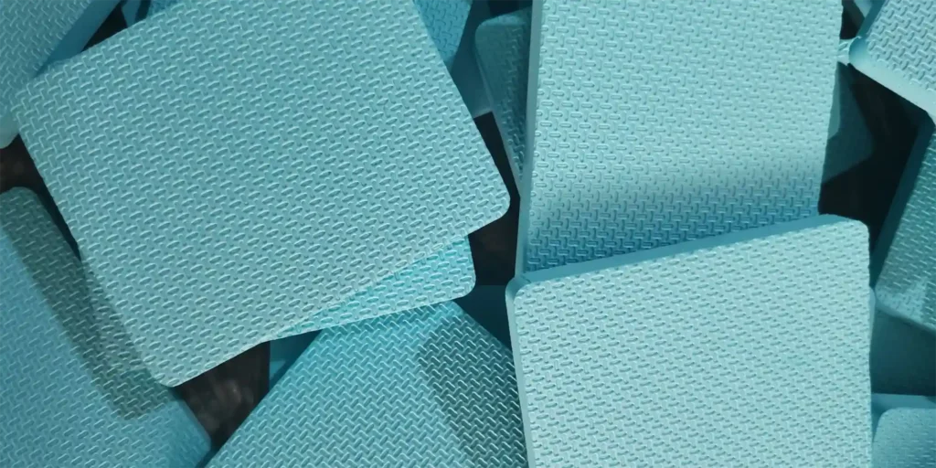 AlternativeText: Light - blue textured foam pieces stacked together. Caption: Light - Blue Textured Foam Pieces Description: This image features multiple light - blue foam pieces, each showcasing a distinct textured pattern. The foam pieces are arranged in a somewhat overlapping manner, highlighting their uniform color and intricate surface design. The texture appears to be a repetitive, woven - like pattern, adding both visual interest and potential functional benefits, such as enhanced grip or durability. The overall scene emphasizes the material’s aesthetic and structural characteristics, making it suitable for applications where both protection and a specific tactile quality are required.